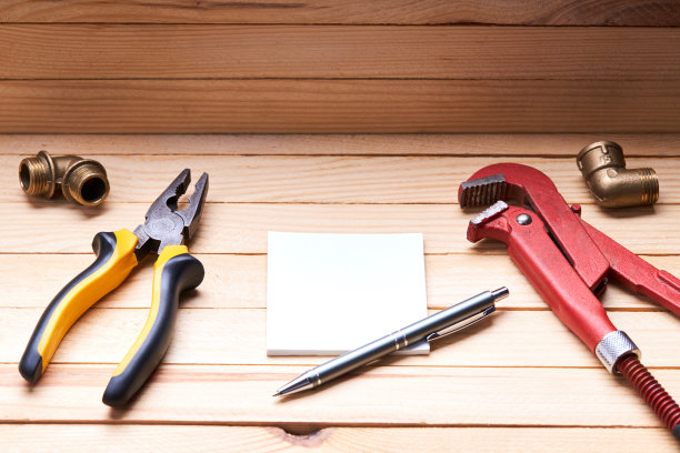 用于调整管道泄漏的管道工具和附件。木桌子的背景。水管工服务理念。解决房子问题图片下载
