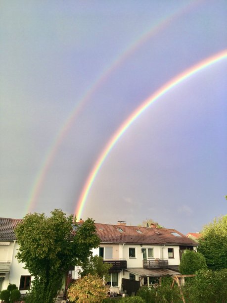 香草味的天空和教堂附近的双彩虹。图片下载