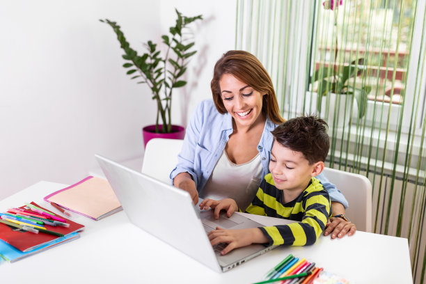 这是一个小男孩在家接受母亲教育的照片。在冠状病毒爆发期间，学校已经关闭，课程转移到电子学习平台。图片下载