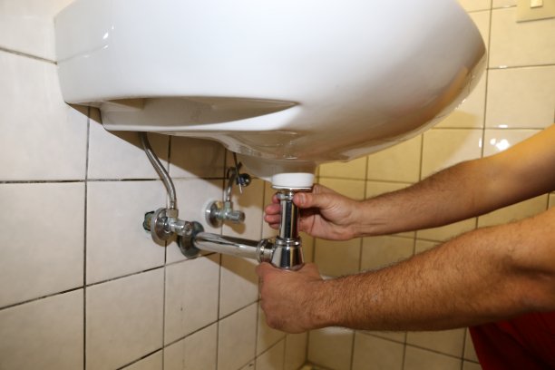 水管工在水槽上安装虹吸管图片下载