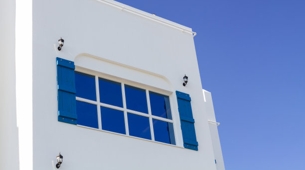 漂亮的白色房子，蓝色的木窗户。副本的空间。图片下载