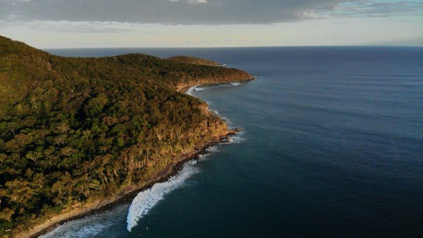 热带岛屿，有深蓝色的海水，旁边是森林覆盖的山图片下载