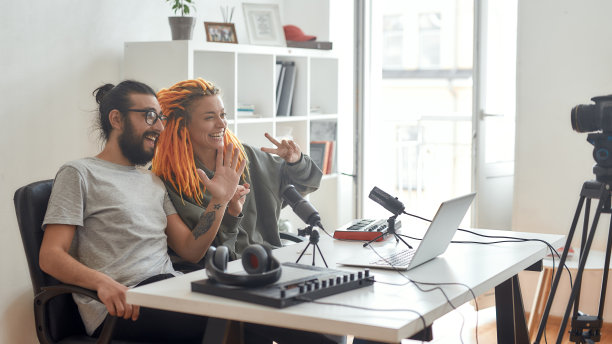 嗨,家伙。在家里录制视频博客或视频博客时，男女博主会向订阅者问好。男人和女人用合成器，鼓垫机制作音乐图片下载
