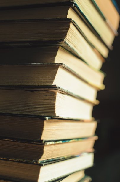 图书馆里有许多为大学考试准备的教育书籍，背景是黑色的图片下载