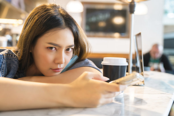 在机场候机厅咖啡厅用手机放松的亚洲年轻女性旅客图片下载