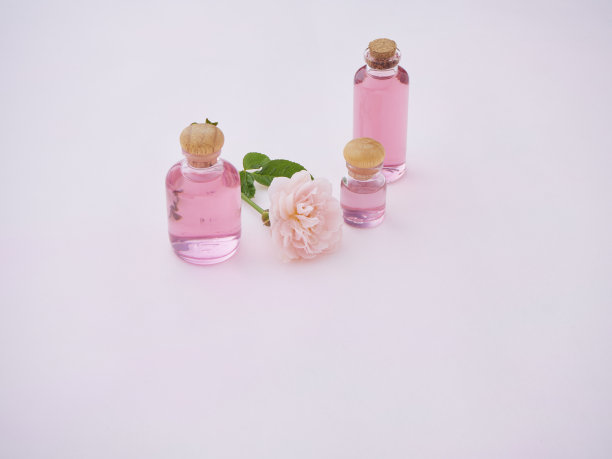 香薰油瓶与玫瑰在粉红色的背景图片下载