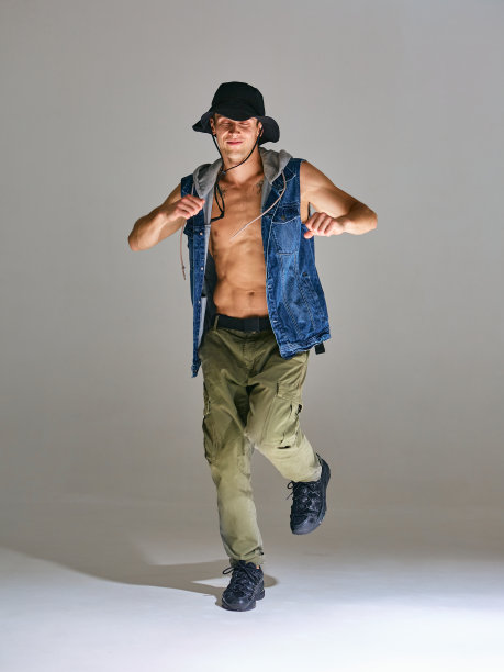 运动的年轻人霹雳舞在帽子跳舞嘻哈在工作室孤立的灰色背景。打破舞蹈课图片下载