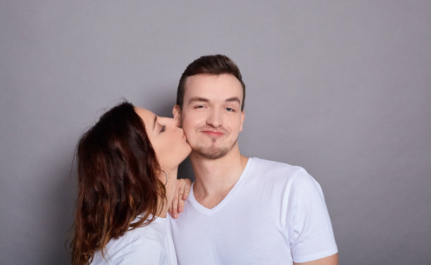 喜气洋洋的情侣在爱的拥抱和亲吻。图片下载