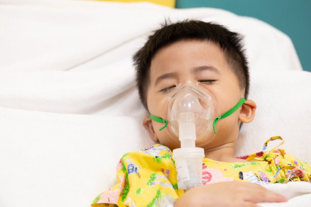 亚洲小男孩在医院用喷雾器做吸入，喷雾器概念图片下载