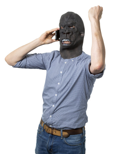 一名戴着大猩猩面具的男子举起拳头在手机上愤怒图片下载