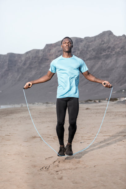 在海滩上用绳子跳的黑人图片下载