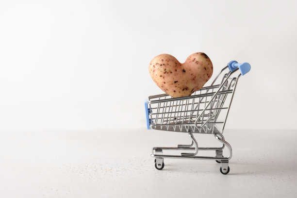 心形的有机土豆飞进了购物车。图片下载