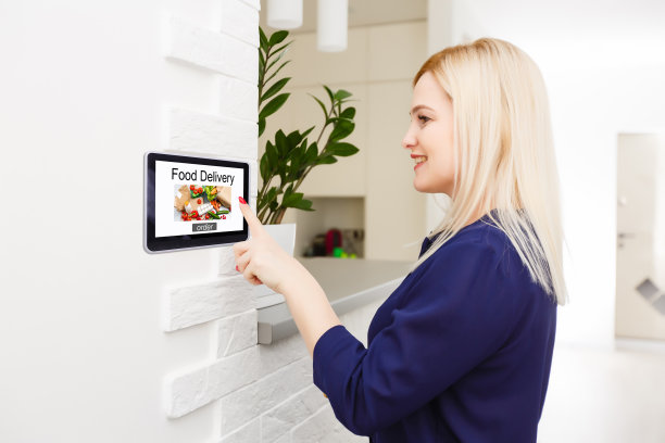 女孩用智能手机在网上订披萨，背景是桌子、咖啡和植物图片下载