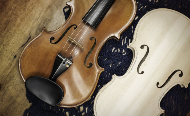 原装小提琴和成品小提琴的正面放在木板上。图片下载