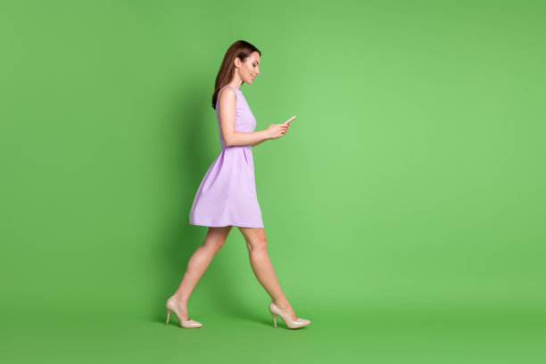 可爱的漂亮的可爱的年轻女孩的全尺寸照片女士去空的空间看电话类型聊天博客自由通信穿紫色的衣服孤立的淡绿色的颜色背景图片下载