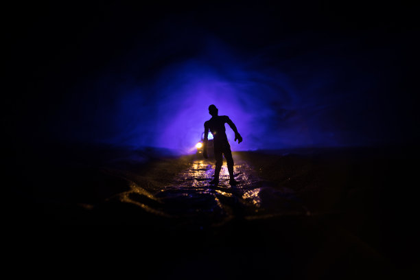 一辆停在路上的车点燃了僵尸的照片。可怕的僵尸剪影夜晚附近的汽车。小型装饰。图片下载