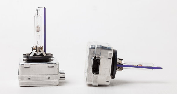 氙气灯是一种用于白色背景的汽车前灯的新灯。氙气是一种新型的汽车前照灯。来自垃圾场的二手汽车零件目录。图片下载