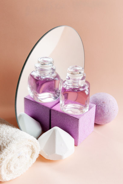 薰衣草香皂，洗发精，毛巾和芳香浴弹反射在一个圆形的镜子。水疗，美容，健康沙龙，化妆品商店的概念。近距离照片上的玫瑰背景。图片下载