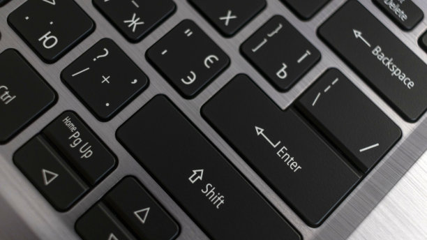 笔记本电脑键盘关闭。金属背景上的黑色英文俄文字母图片下载