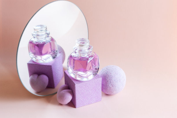 薰衣草香皂，洗发精和芳香浴弹反射在一个圆形的镜子。水疗，美容，健康沙龙，化妆品商店的概念。近距离照片上的玫瑰背景。图片下载
