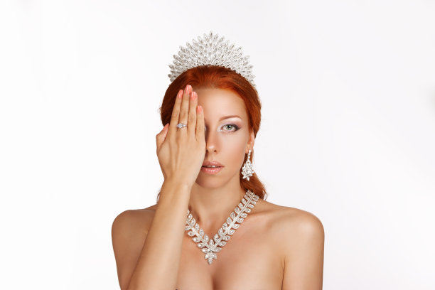 美丽加冕的女王姑娘姑娘小姐新娘手，显示美甲凝胶艺术指甲漂亮的女人手在脸上与水晶皇冠的头孤立在浅灰色的背景图片下载