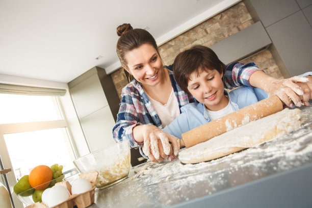 一家人在家里站在厨房里一起吃饭，妈妈帮儿子擀面团开心极了图片下载
