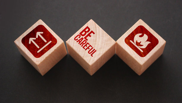 木质立方体，上面写着:小心，图标代表易燃，不能倒置。小心的概念图片下载