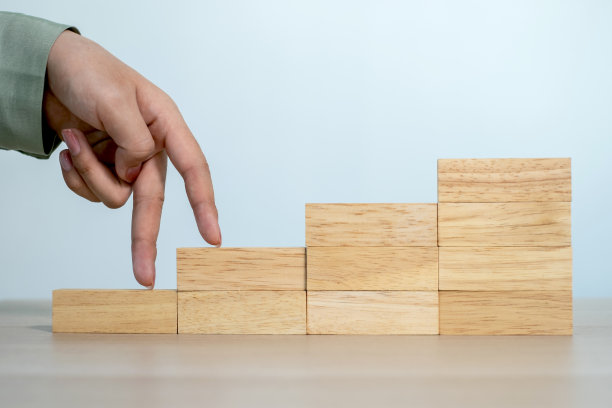 商界女性的手正在攀爬一块木头，为目标而奋斗的概念或目标图片下载