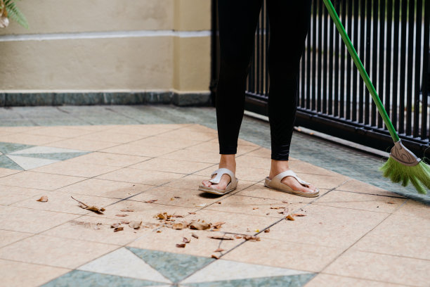 年轻的亚洲妇女打扫和清洁前院图片下载