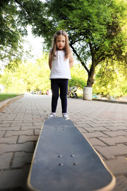 一个患有唐氏综合症的女孩玩滑板图片下载