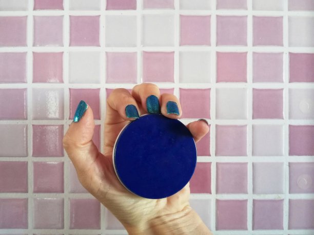 涂着蓝色指甲油的女性手拿着蓝色的奶油盒子图片下载