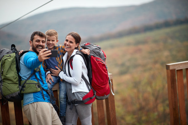 幸福的夫妇和一个儿子在徒步旅行;春天或秋天在大自然中远足;露营，旅游，旅游，生活方式，徒步和人的概念。高质量的家庭活动时间。图片下载