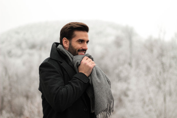 一个英俊的男人期待着第一场雪和一个寒冷的冬天图片下载