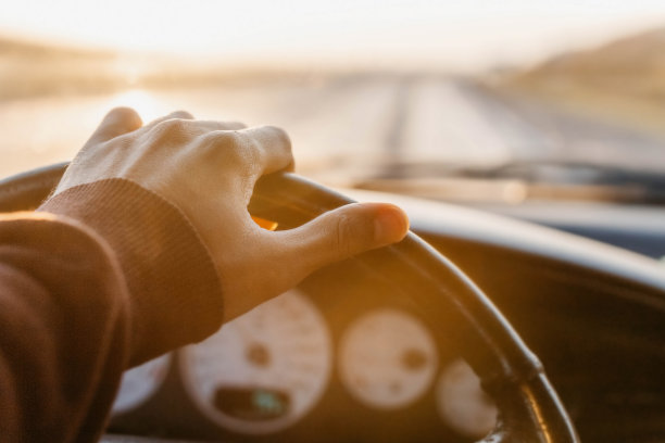 作为一名司机的工作理念，在日落时把手放在方向盘上。图片下载