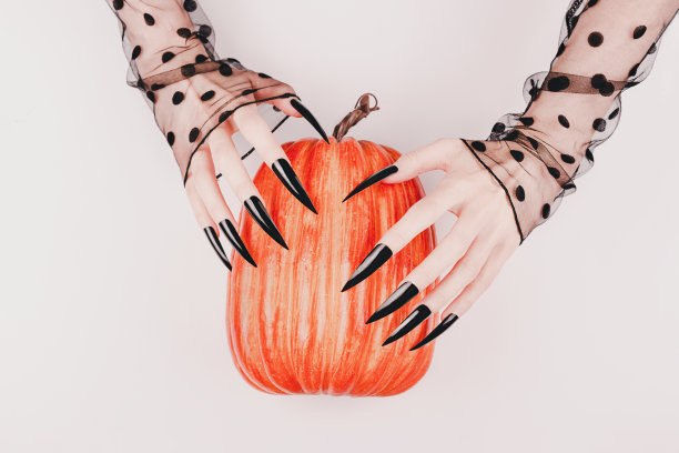 有着长指甲和南瓜的女巫之手。图片下载