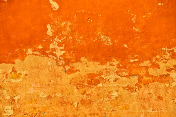 明亮而充满活力的橙色服饰，抹在墙上，古老而古老，饱经风霜图片下载