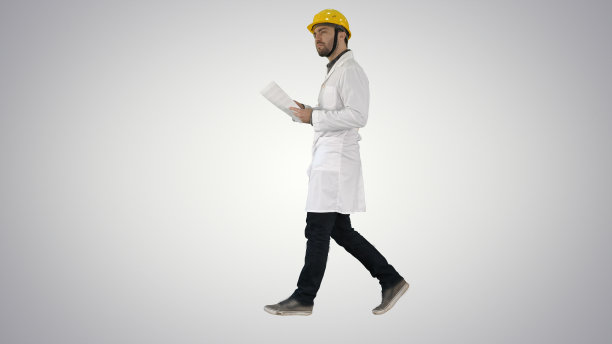 工程师经理戴着安全帽走着，手里拿着纸和支票图片下载