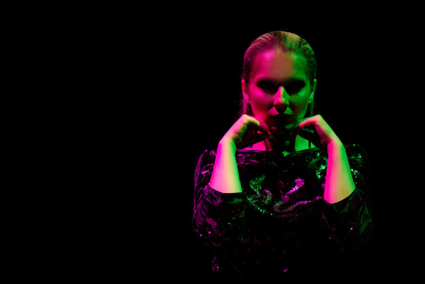 性感女孩穿着黑色的时尚照片在夜总会。夜店女郎霓虹概念。图片下载