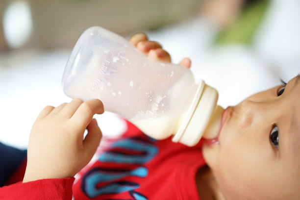 可爱的小男孩喝着牛奶图片下载