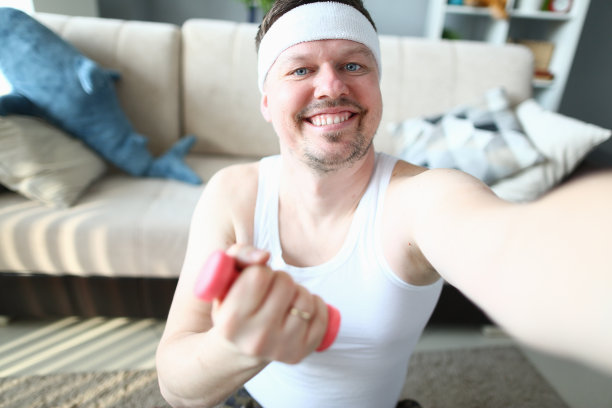 一个开心的男人在家里晨练时自拍图片下载