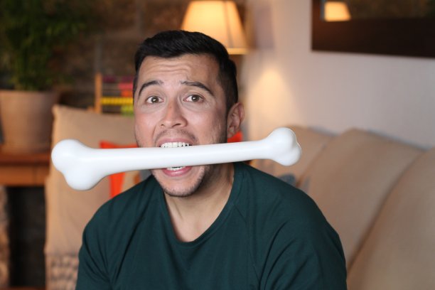 年轻人嘴里叼着大块骨头图片下载