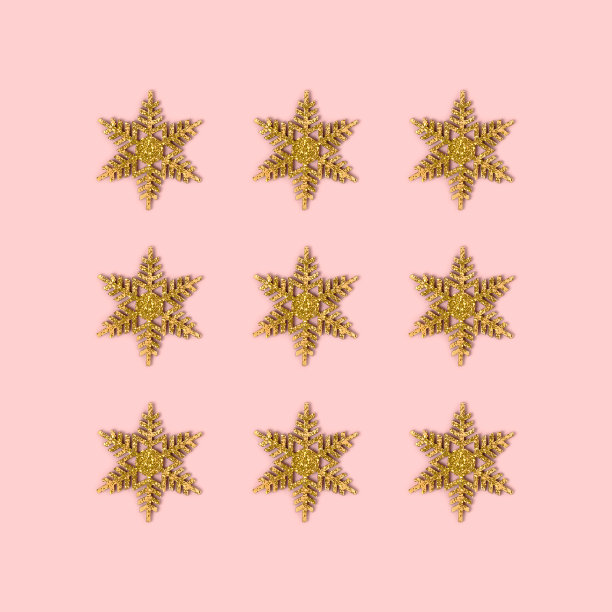 金色的雪花布局在粉红色的背景。图片下载