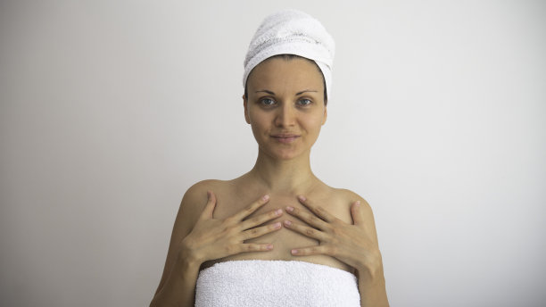 白种女人，头和身体都裹在干净的白毛巾里。美容化妆品和水疗治疗概念。图片下载