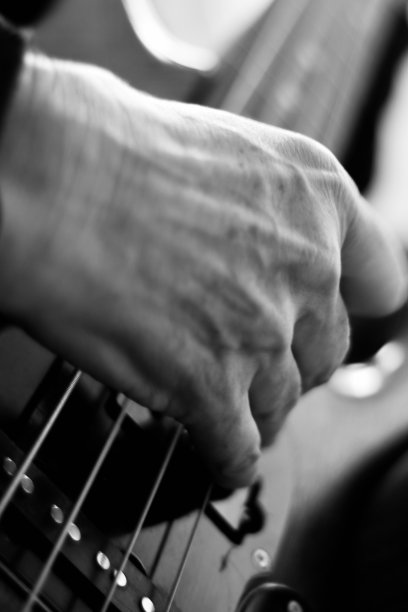 近距离的手弹奏低音吉他图片下载
