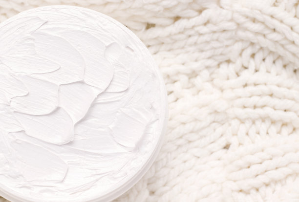 奶油的特写纹理的白色针织织物。冬天化妆品的概念。从以上观点。本空间图片下载