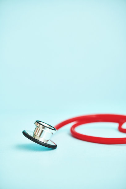 浅蓝色背景下的亮红色听诊器图片下载