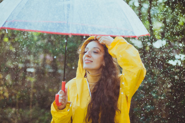 秋雨中带着透明塑料伞的快乐女人图片下载