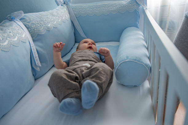 微笑的小男孩在他的婴儿床。图片下载