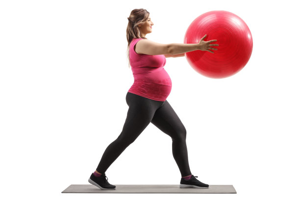 一名孕妇用健身球运动的全长侧面照片图片下载