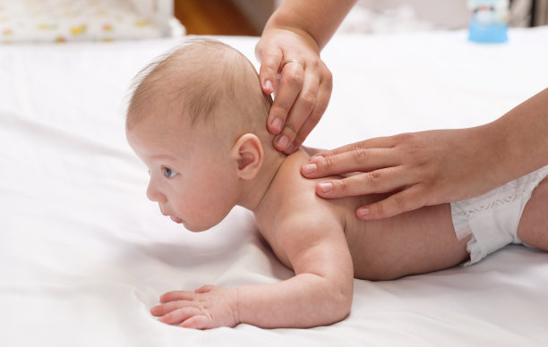 宝宝按摩，特写手放在宝宝背部图片下载